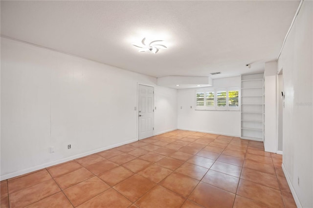 spare room with light tile patterned floors and a textured ceiling