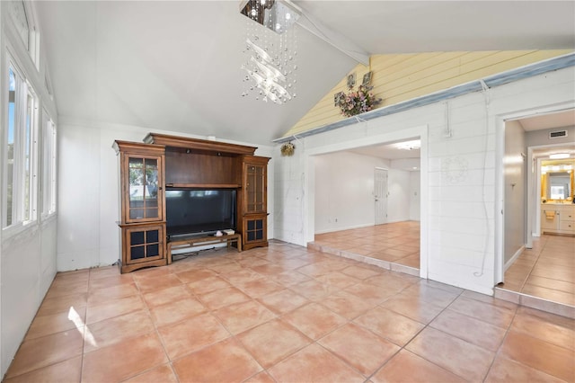 unfurnished living room featuring tile patterned floors, vaulted ceiling with beams, a wealth of natural light, and a notable chandelier