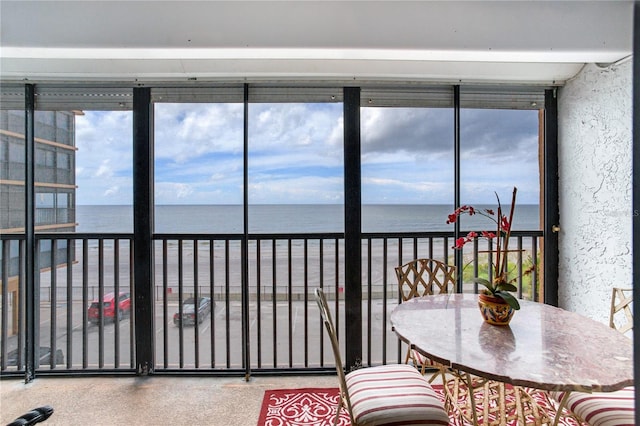 sunroom / solarium featuring a water view