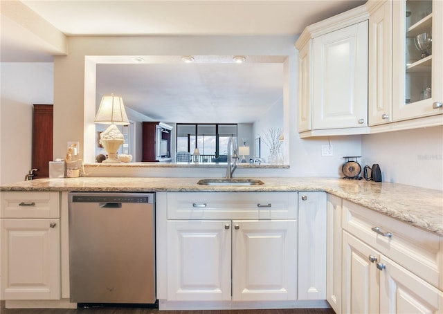 kitchen with white cabinets, light stone countertops, stainless steel dishwasher, and sink