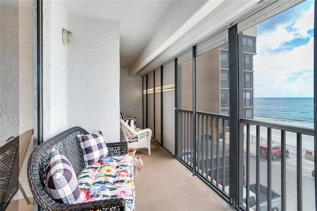 balcony featuring a beach view and a water view