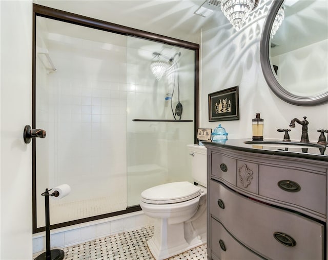 bathroom with a shower with door, vanity, toilet, and tile patterned flooring