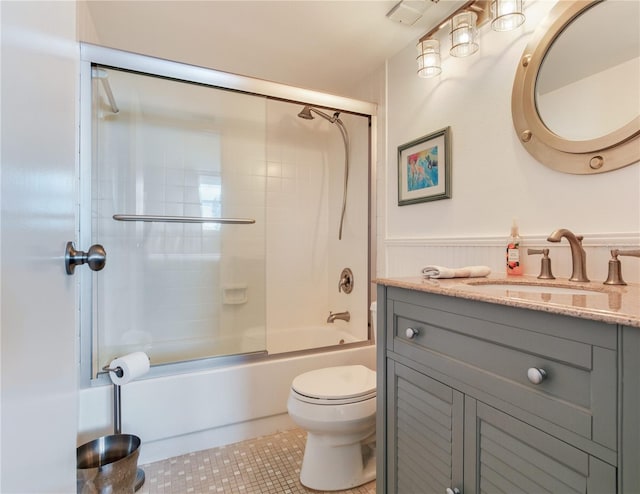 full bathroom with combined bath / shower with glass door, vanity, toilet, and tile patterned floors