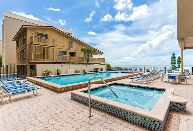 view of pool featuring a community hot tub and a patio