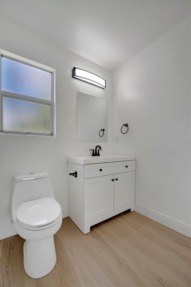 bathroom featuring vanity, hardwood / wood-style floors, and toilet