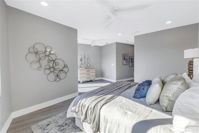 bedroom with baseboards, wood finished floors, and recessed lighting