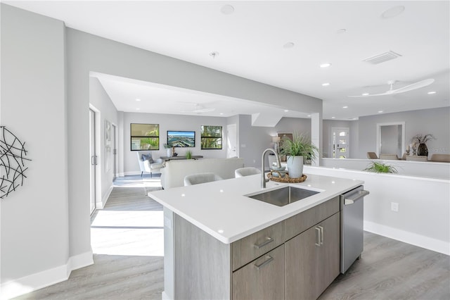 kitchen featuring dishwasher, ceiling fan, open floor plan, and a sink