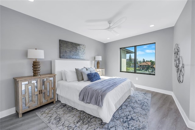 bedroom with ceiling fan, baseboards, and wood finished floors