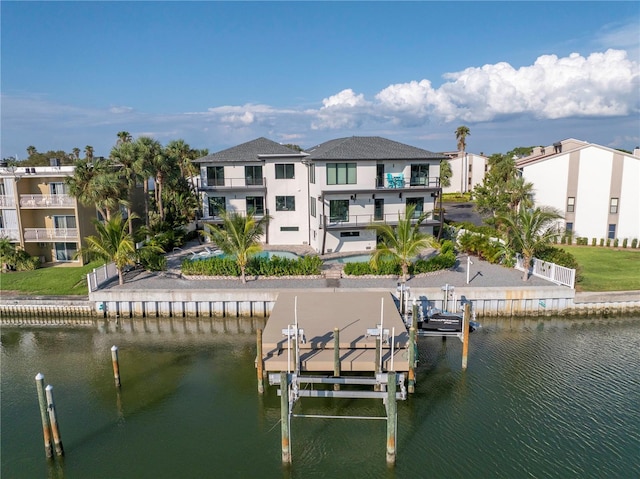 dock area featuring a patio, boat lift, a balcony, a water view, and a swimming pool