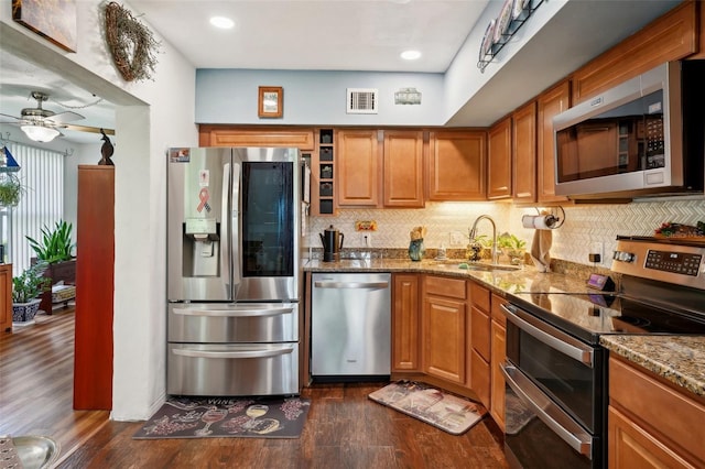 kitchen with backsplash, dark hardwood / wood-style flooring, sink, ceiling fan, and appliances with stainless steel finishes