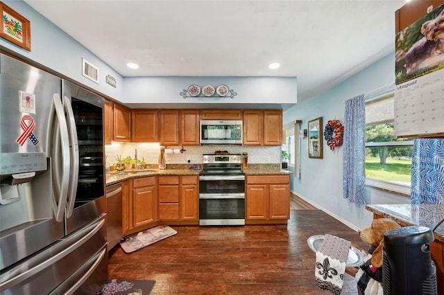 kitchen featuring tasteful backsplash, stainless steel appliances, light stone countertops, and dark hardwood / wood-style floors