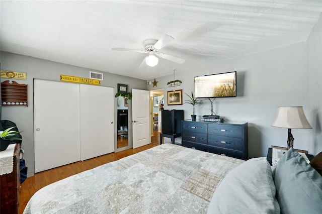 bedroom featuring wood-type flooring, ceiling fan, and a closet