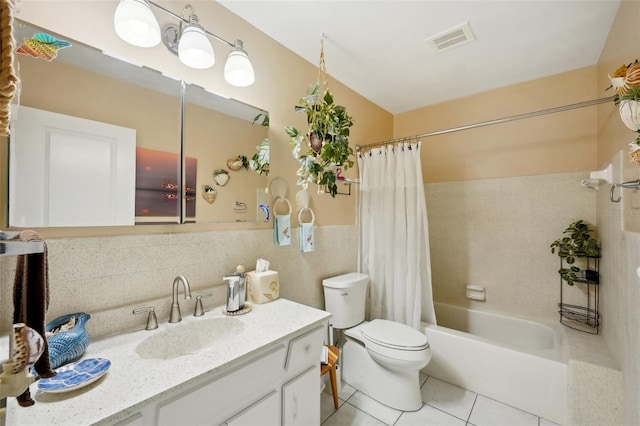 full bathroom featuring toilet, tile patterned floors, vanity, tasteful backsplash, and tile walls