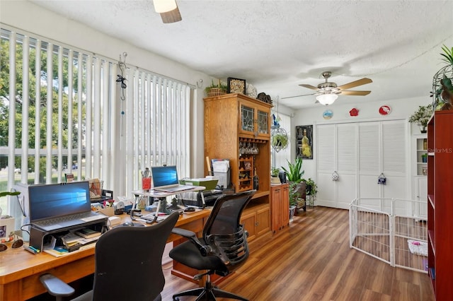 home office featuring a textured ceiling, ceiling fan, and wood-type flooring