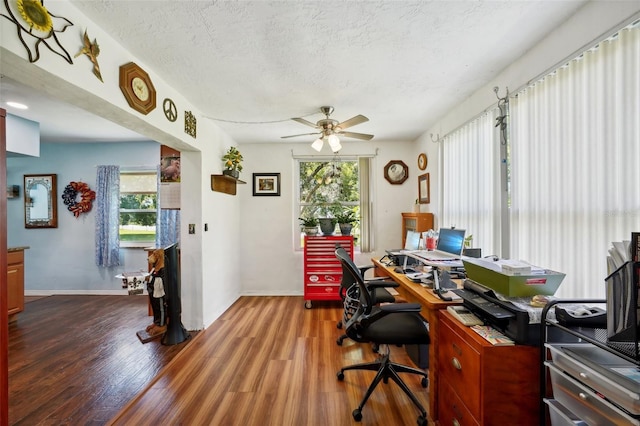 office featuring dark wood-type flooring, ceiling fan, and a textured ceiling