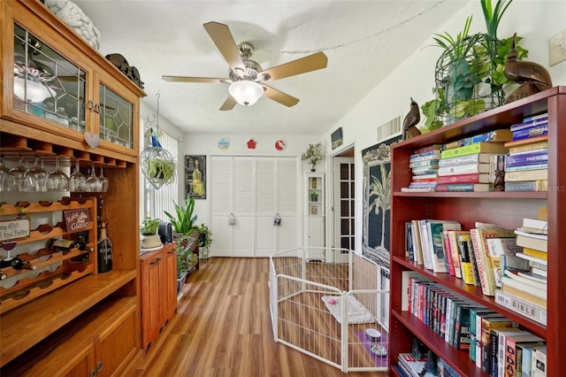 sitting room featuring a textured ceiling, ceiling fan, and light hardwood / wood-style floors