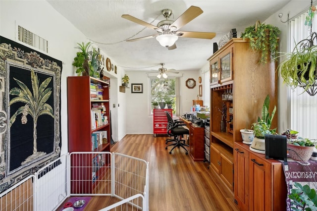 office featuring ceiling fan, hardwood / wood-style flooring, and a textured ceiling