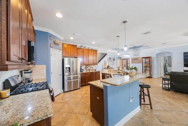 kitchen featuring appliances with stainless steel finishes, sink, a large island, pendant lighting, and a breakfast bar