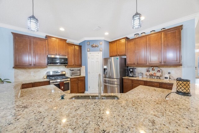 kitchen with light stone countertops, stainless steel appliances, sink, and pendant lighting