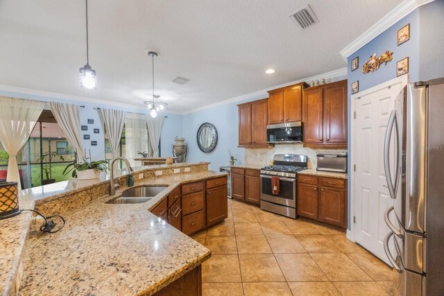 kitchen featuring hanging light fixtures, ornamental molding, sink, appliances with stainless steel finishes, and light stone counters