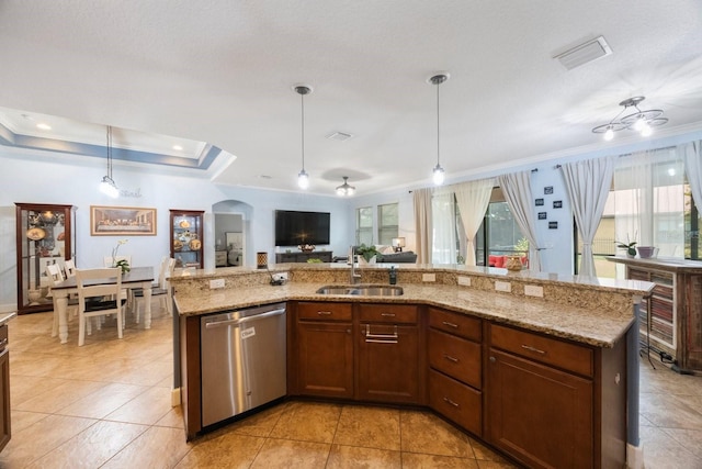 kitchen featuring a kitchen island with sink, light stone countertops, dishwasher, pendant lighting, and sink