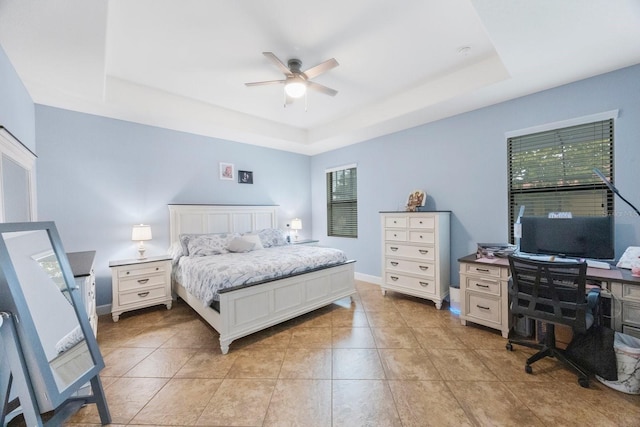 tiled bedroom featuring ceiling fan and a raised ceiling