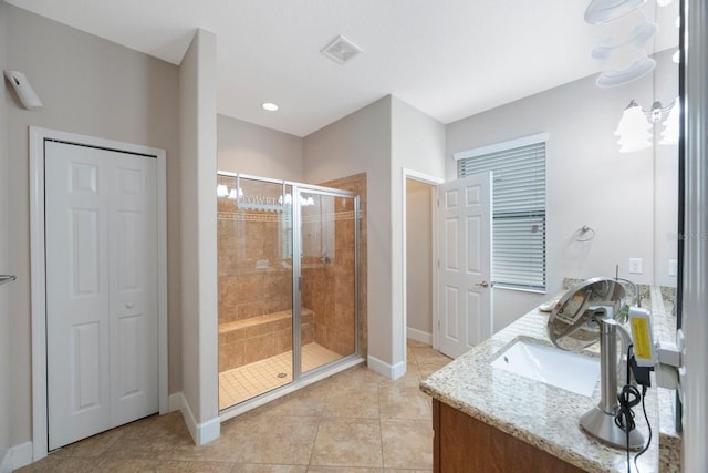 bathroom featuring vanity, a shower with shower door, and tile patterned floors