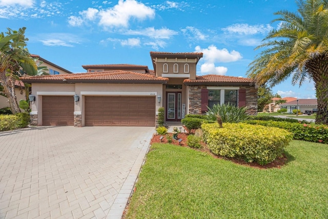 mediterranean / spanish-style home with a front yard and a garage