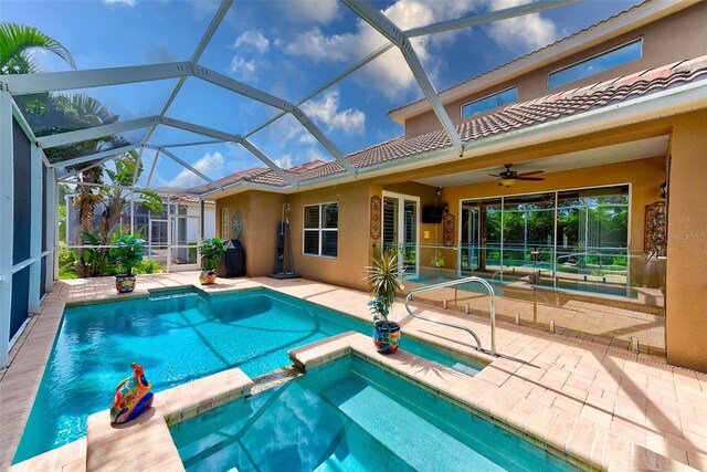 view of swimming pool with a lanai, a pool with connected hot tub, a patio, and a ceiling fan