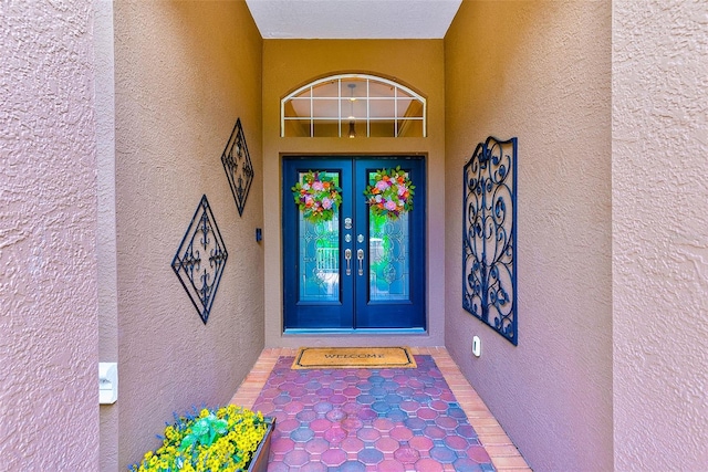 entrance to property featuring french doors and stucco siding