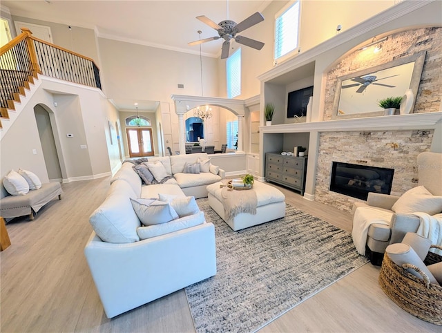 living area with wood finished floors, arched walkways, and ceiling fan