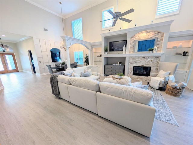 living room featuring built in features, arched walkways, and a wealth of natural light