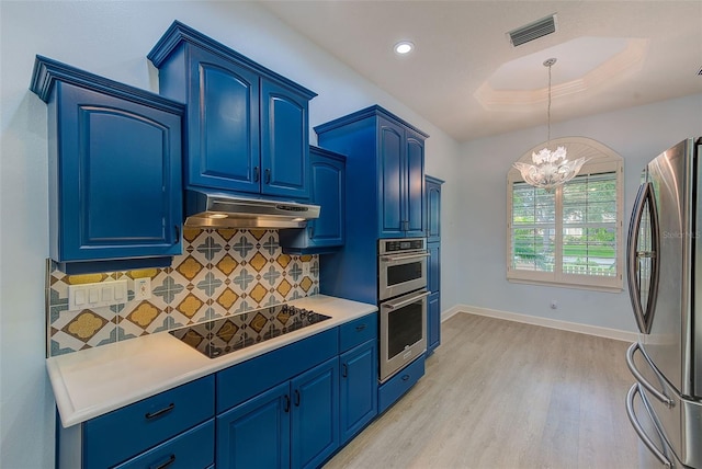 kitchen with visible vents, under cabinet range hood, blue cabinetry, stainless steel appliances, and a chandelier