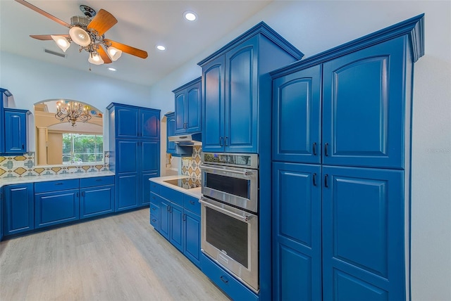 kitchen featuring blue cabinets, visible vents, backsplash, stainless steel double oven, and light wood finished floors