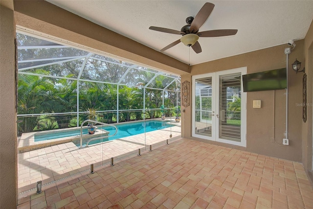 outdoor pool with french doors, ceiling fan, glass enclosure, and a patio area