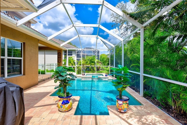 view of pool featuring glass enclosure, a patio, grilling area, and a pool with connected hot tub