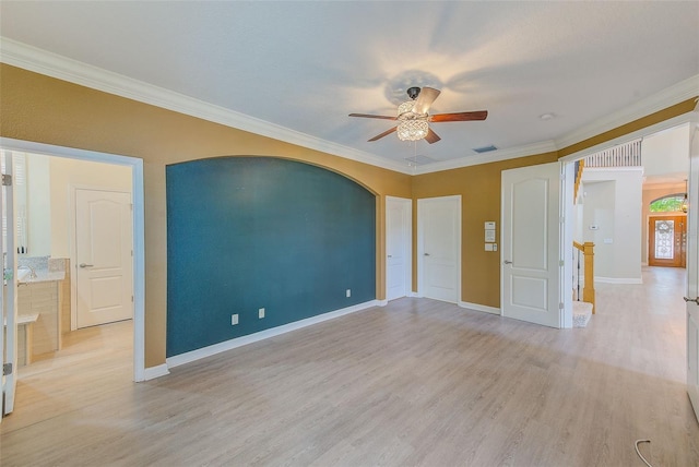 empty room with visible vents, light wood-type flooring, ceiling fan, and ornamental molding