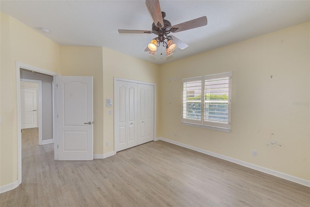 unfurnished bedroom with a closet, baseboards, light wood finished floors, and ceiling fan