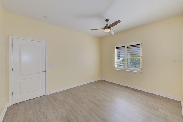 spare room with baseboards, wood finished floors, and ceiling fan