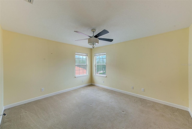 unfurnished room featuring a ceiling fan, light colored carpet, and baseboards