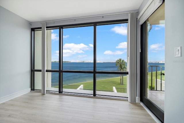 unfurnished room featuring a water view and a wealth of natural light