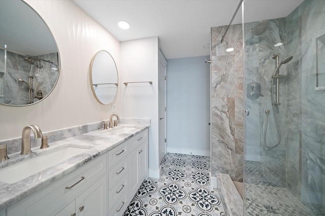 bathroom with tiled shower, vanity, and tile patterned floors