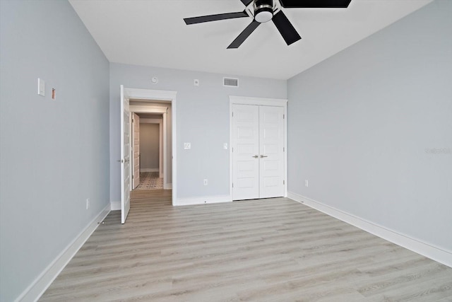 unfurnished bedroom featuring light wood-type flooring, a closet, and ceiling fan