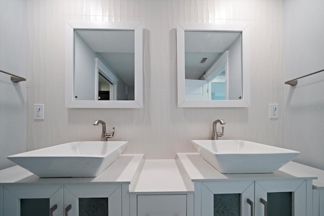 bathroom with vanity and tile walls