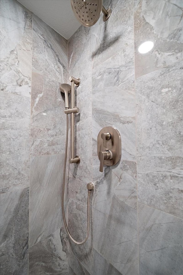 interior details featuring tiled shower