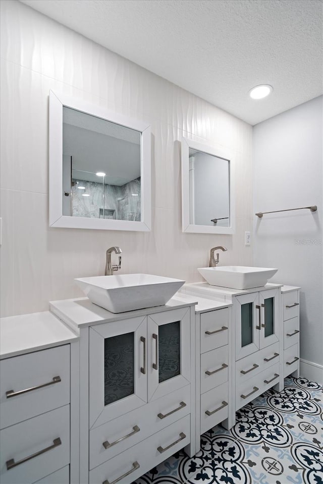 bathroom featuring vanity, a textured ceiling, and walk in shower