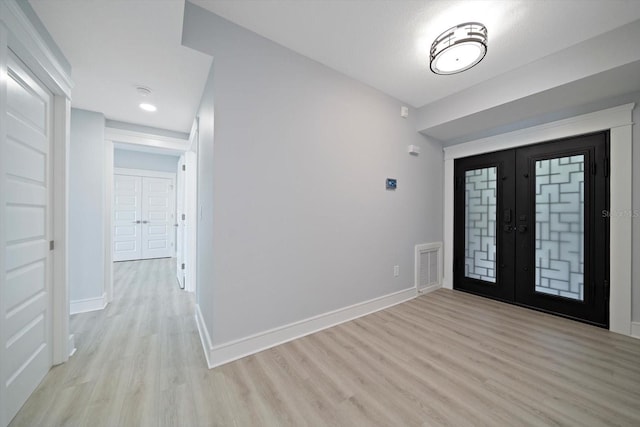 entrance foyer with french doors and light hardwood / wood-style flooring