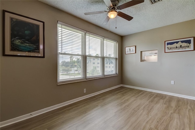 unfurnished room featuring a textured ceiling, light hardwood / wood-style flooring, ceiling fan, and plenty of natural light