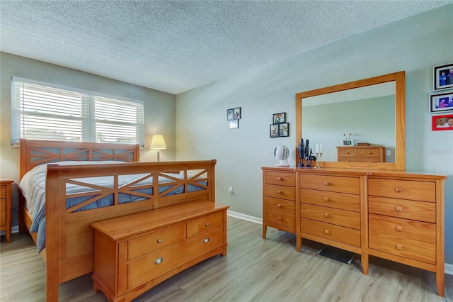 bedroom with light hardwood / wood-style floors and a textured ceiling