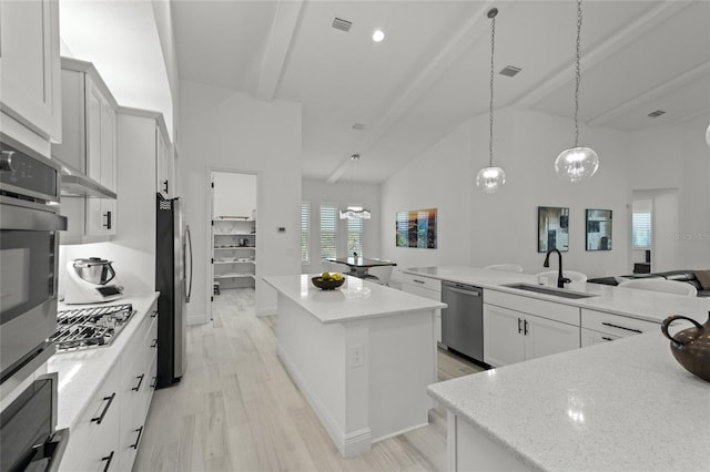 kitchen featuring a kitchen island, pendant lighting, appliances with stainless steel finishes, beam ceiling, and high vaulted ceiling